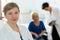 Smiling blonde haired doctor standing in office