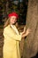 Smiling blonde teenager in yellow coat and red beret  outdoors on warm day
