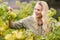 Smiling blonde winegrower holding a grape