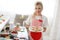 Smiling blonde woman cooking cupcakes in kitchen