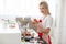 Smiling blonde woman cooking cupcakes in kitchen