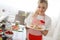 Smiling blonde woman cooking cupcakes in kitchen