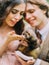 The smiling blurred newlywed couple holding and petting the brown ferret.