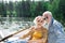 Smiling in boat. Positive active couple of pensioners smiling and feeling happy while sitting in their little boat