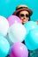 Smiling bohemian girl standing with helium balloons