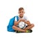 A smiling boy with a ball and a blue satchel sitting in a yoga pose. Happy child isolated on a white background. Sports