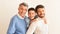 Smiling Boy, Father And Grandfather Hugging Standing Against White Background