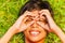 Smiling boy with hands on face in glasses shape