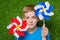 Smiling boy holding pinwheels over grass close up