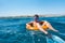 Smiling boy learns to swim on lifebuoy in the sea