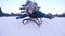 Smiling boy lying on sled rides from snow-covered hill in winter forest in slow motion