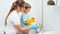 Smiling boy with mother washing bath and water sink. Children helping adults in housework and home cleanup.