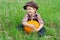Smiling boy with pumpkin on the grass