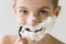 Smiling Boy Shaving Face with Plastic Razor