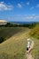 A smiling boy in shorts and a T-shirt stands on a path against the backdrop of a summer panorama of the Zhiguli Mountains.