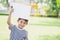 Smiling boy standing with empty horizontal blank in hands. Cute little boy with white sheet of paper.