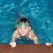 A smiling boy is swimming in the pool. Sports and recreation. Beautiful people