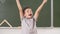 Smiling boy thumb up going to school for first time. Kid indoor class room board on background