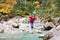 Smiling boy trying to cross wild mountain river