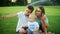 Smiling boys and girl sitting on green meadow. Kids taking selfie on smartphone