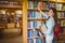 Smiling brunette student picking out book