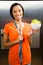 Smiling brunette with tape measure around neck holding bowl of salad