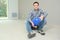 Smiling builder sitting on floor in empty home