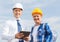 Smiling builders in hardhats with tablet pc