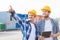 Smiling builders in hardhats with tablet pc