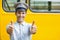 Smiling bus driver showing thumbs up in front of bus