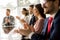 Smiling business group clapping hands at the meeting