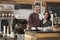 Smiling business owners behind the counter of their cafe