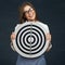 Smiling business woman holding black white target.