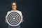 Smiling business woman holding black white target.