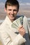 Smiling businessman with batch of dollars