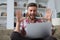 Smiling businessman greeting colleagues in video conference and negotiating distantly from home