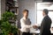 Smiling businessman shaking hand of African American colleague, greeting