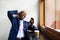 Smiling businessman sitting at a cafe looking at mobile phone