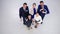 Smiling businesspeople showing thumbs up and peace hand sign in office