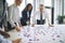 Smiling businesspeople solving a puzzle on an office table