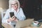 Smiling businesswoman dressed in white shirt is sitting at table