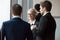 Smiling businesswoman enjoying friendly talk with male colleagues or partners