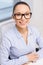 Smiling businesswoman in eyeglasses in office