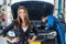 Smiling Businesswoman With Mechanic Repairing Car In Garage