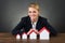 Smiling Businesswoman With Model Houses Arranged In Graph Order