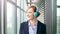 Smiling businesswoman putting on headphones and starts dancing