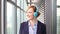 Smiling businesswoman putting on headphones and starts dancing