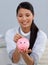Smiling businesswoman saving money in a piggybank