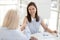 Smiling businesswoman shaking hand of colleague at company meeting