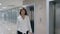 Smiling businesswoman in suit stepping out of elevator